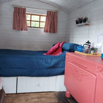 a bedroom with a bed and desk in a room