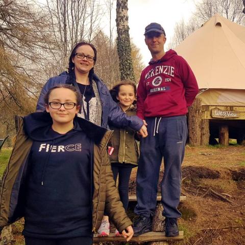 a family in front of bell tent
