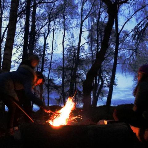 a group of people sitting around a fire