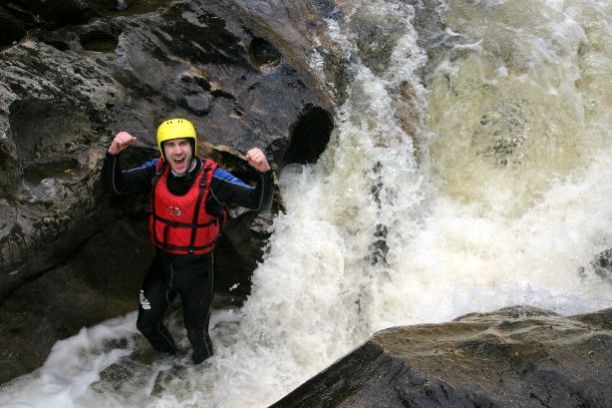 a man standing next to a waterfall