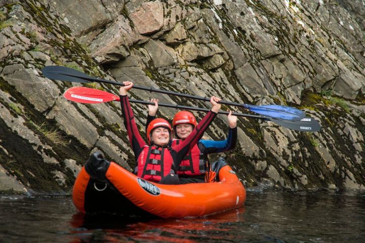 two kayakers holding up their paddles