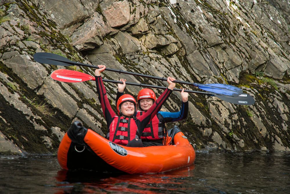 3d7d97880cc776dffa376680e24bd561 two kayakers holding up their paddles