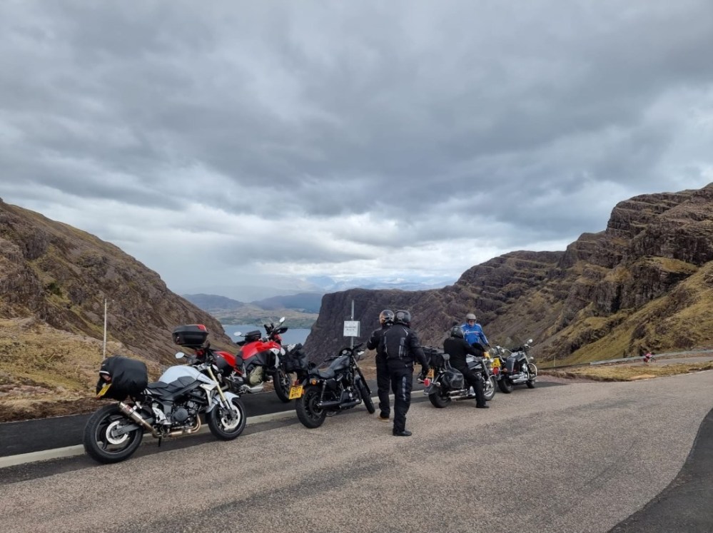 a motorcycle is parked on the side of a mountain road
