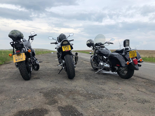 a row of parked motorcycles sitting on the side of a road