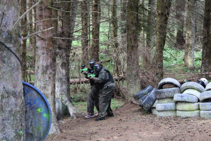 a person standing next to a forest